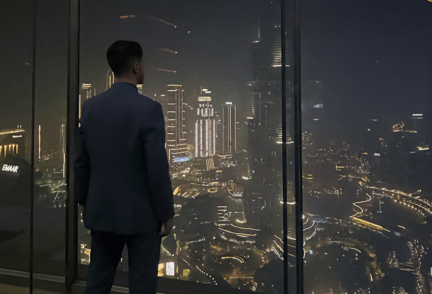 Fernando Barp olhando pela janela de um prédio alto